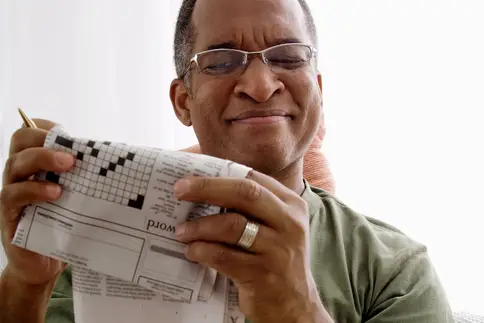 photo of man doing crossword puzzle