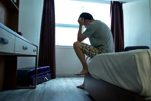 photo of man depressed on bed