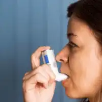 photo of woman using asthma inhaler