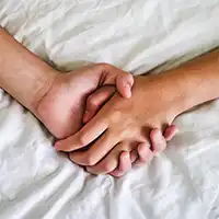 photo of holding hands in bed