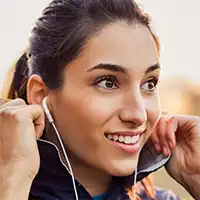 photo of young woman using earbuds