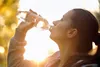 photo of woman drinking water from bottle