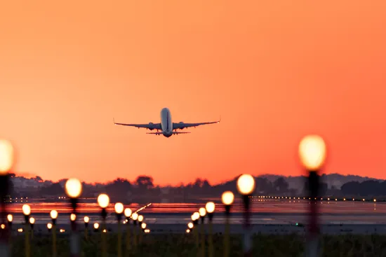 photo of airplane taking off at sunrise