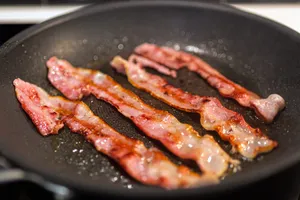 Some people just couldn't have breakfast without a few slices of bacon. It's best to eat in moderation, though. (Photo Credit: Moment / Getty Images)