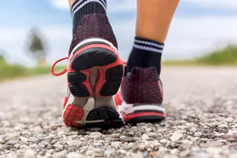 photo of feet of woman walking on country lane