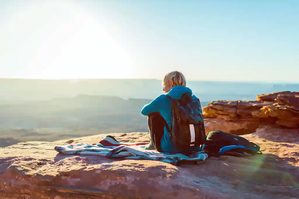 photo of female hiker resting on mountaintop