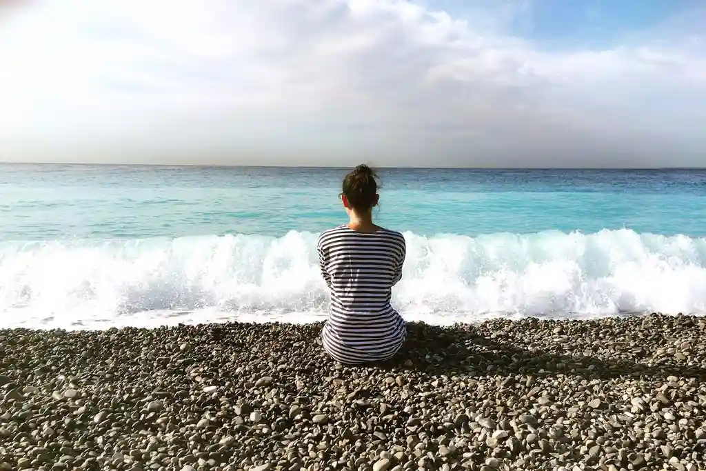 photo of young woman sitting on the beach