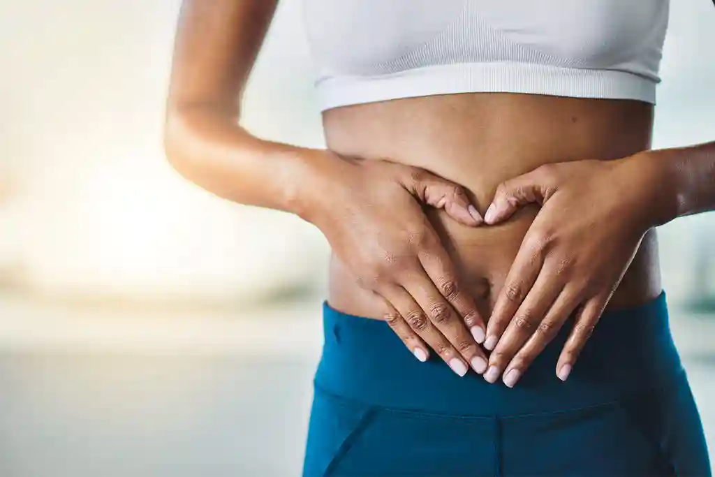 photo of heart-shaped gesture over woman's stomach