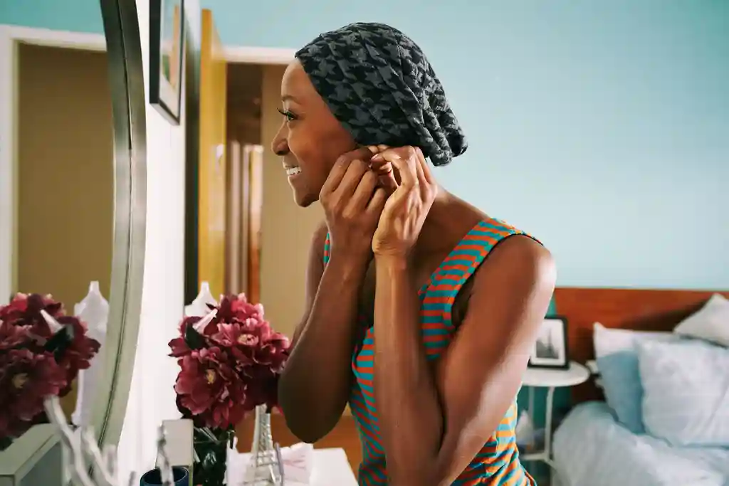 photo of woman putting on earrings