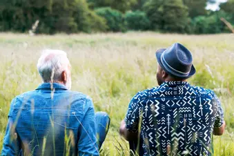 friends sitting in grassy field