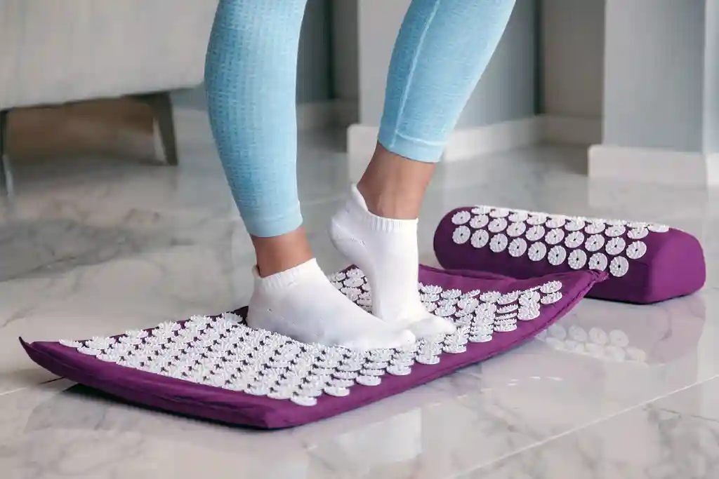 photo of woman standing on acupressure mat
