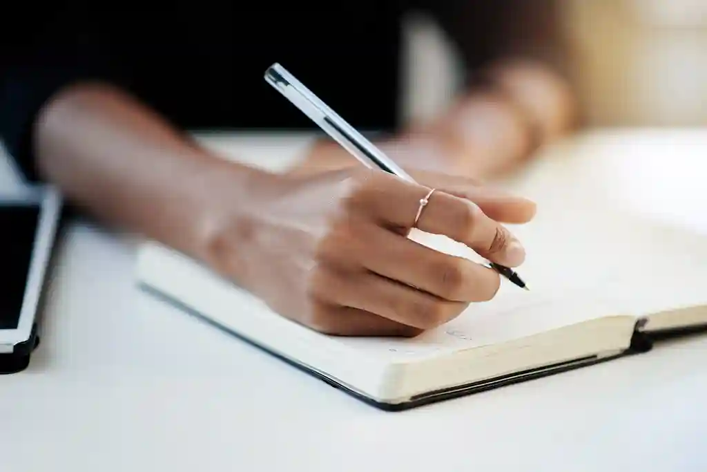 photo of businesswoman writing in notebook