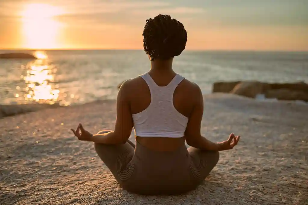 photo of woman practicingyoga on the beach