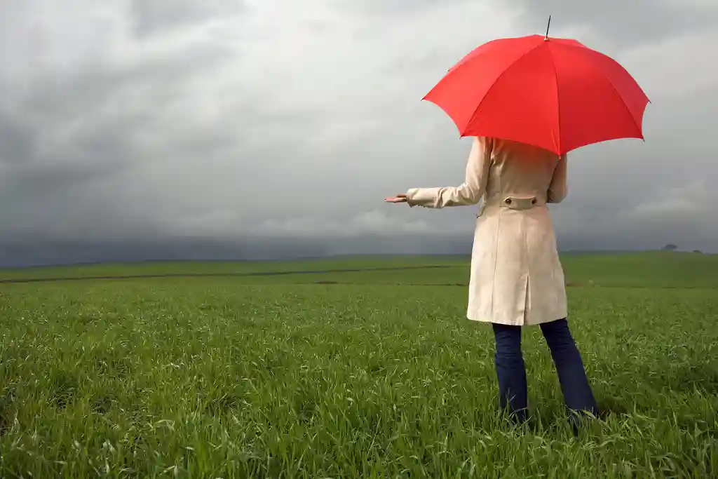 photo of woman holding umbrella in field
