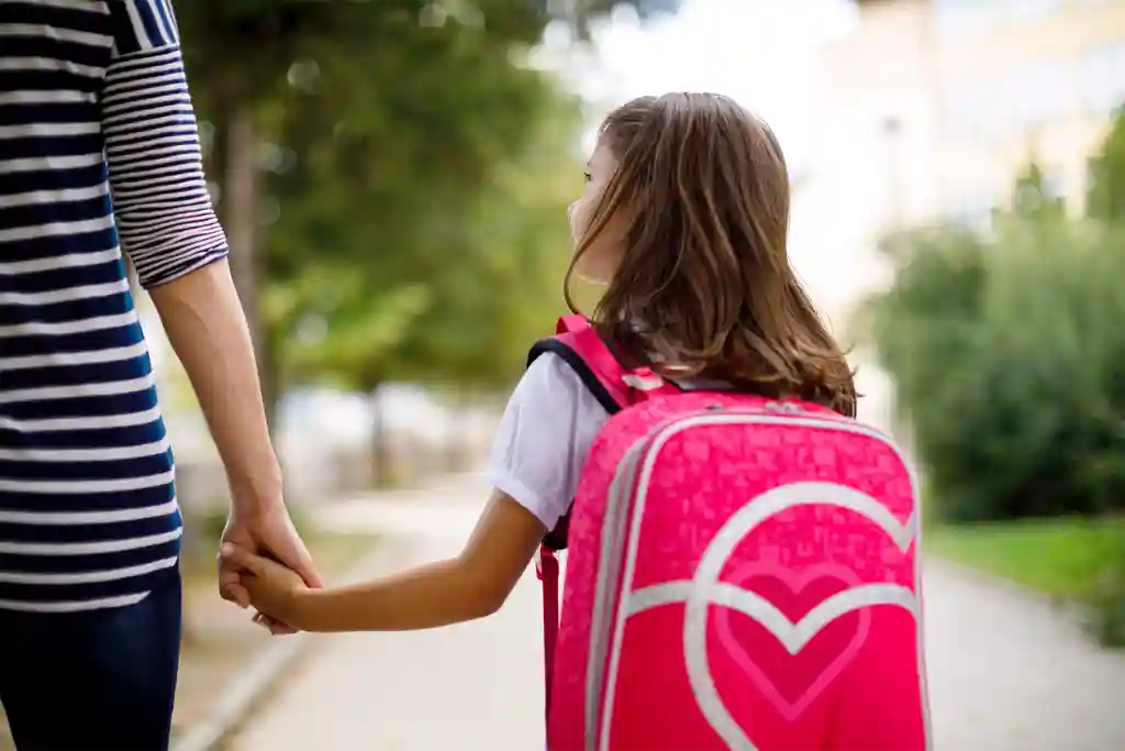 photo of mother taking her daughter to school
