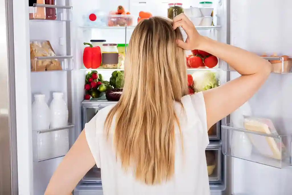 photo of woman looking in refrigerator