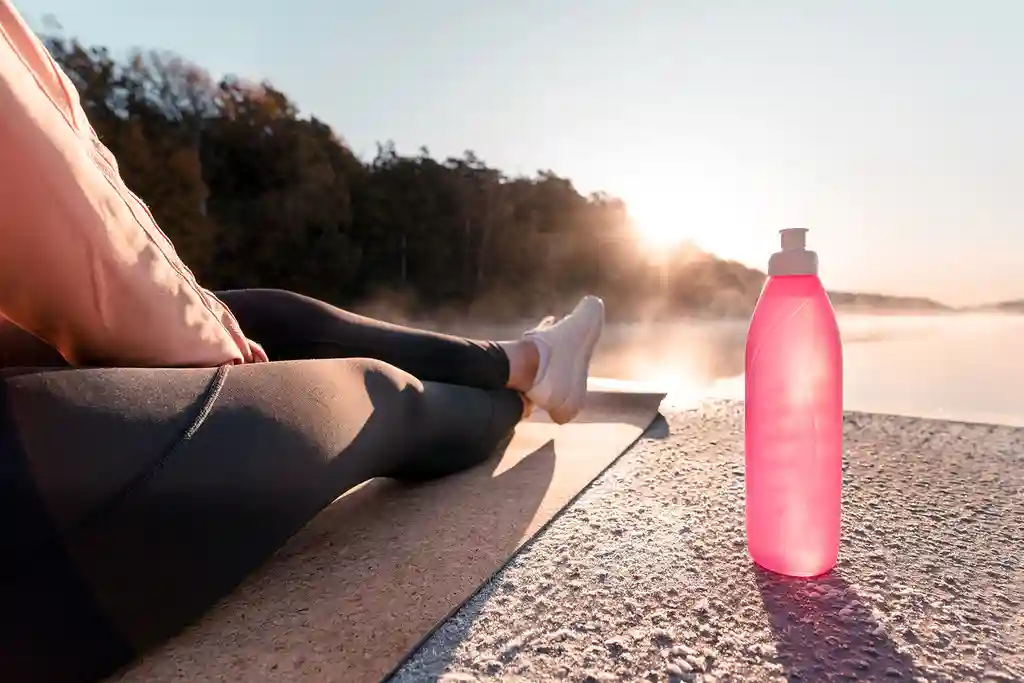 photo of woman exercising by lake at sunrise
