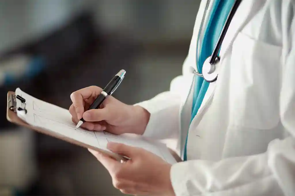 photo of doctor writing on clipboard