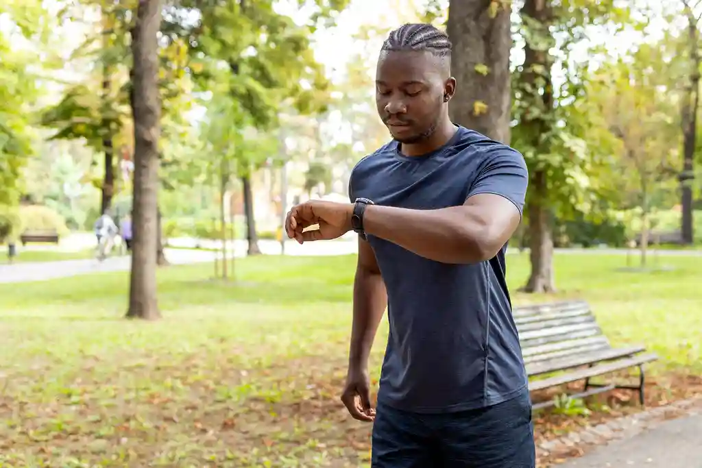 photo of man checking watch while walking