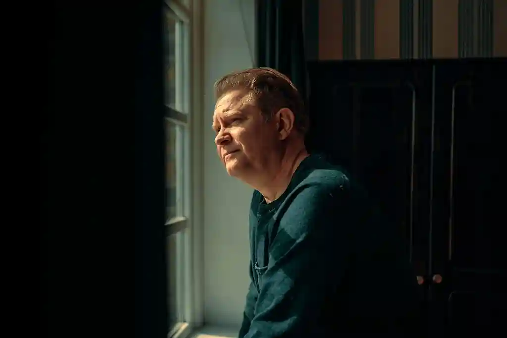 photo of man looking out window