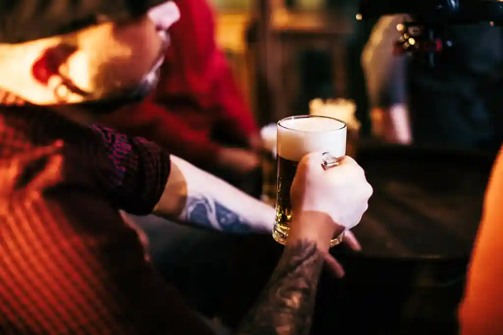 photo of man holding glass of beer