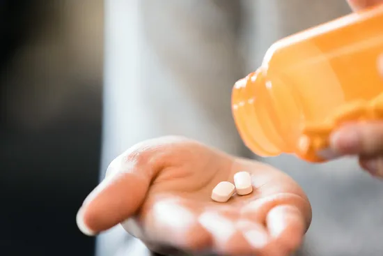 photo of woman pours pills into hand