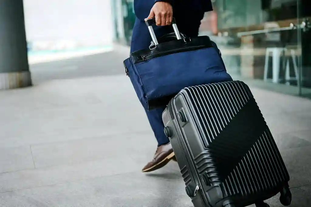 photo of businessman pulling rolling suitcase