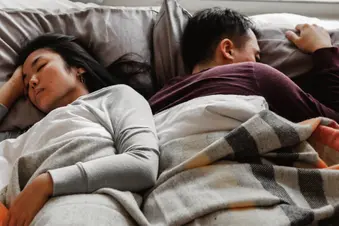 photo of unhappy sleeping couple