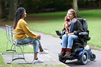 photo of woman in wheelchair talking to friend