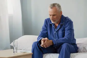 mature man sitting on bed