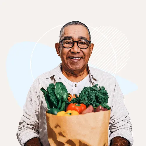 photo of older man holding bag of groceries