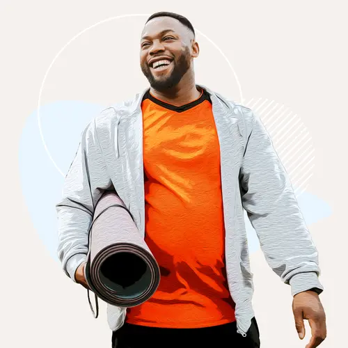 photo of man smiling with yoga mat