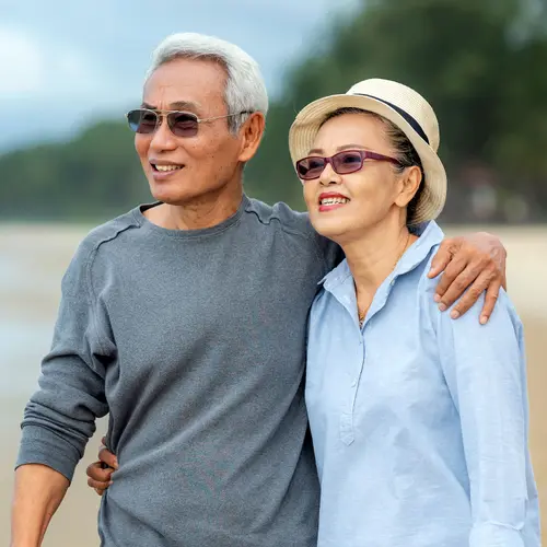 photo of senior couple walking on the beach