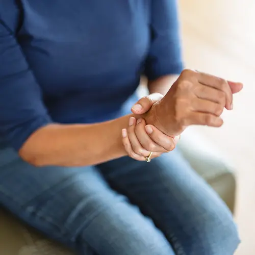photo of woman holding sore wrist