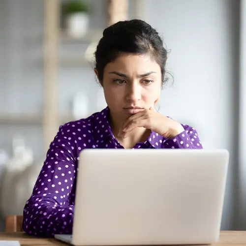 photo of serious woman using laptop
