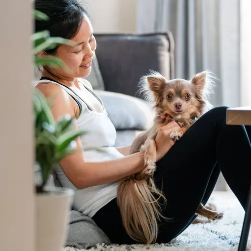 photo of woman relaxing with pet dog at home