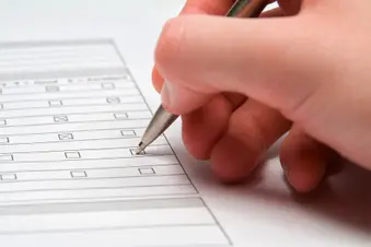 photo of close up of hand filling out questionnair