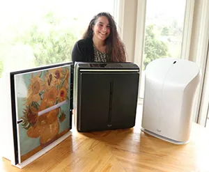 Rabbit Air Customer Service Team lead Olivia Raya next to three air purifiers the company offers. Photo by Chelsea Zhao. 