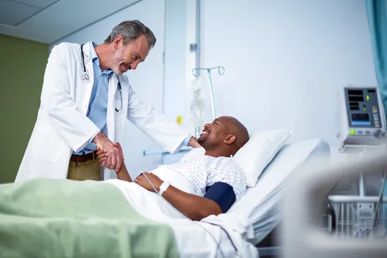 photo of doctor greeting patient in hospital bed