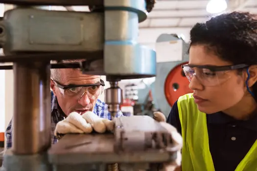 photo of factory workers using drill press