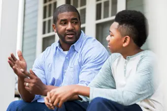 photo of father having serious talk with son