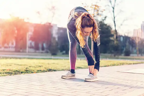 photo of fitness woman stretching legs outside