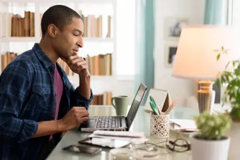 photo of man using laptop at home