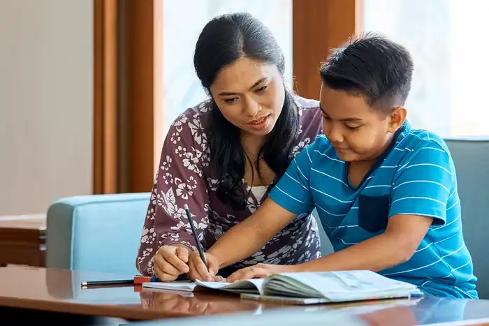photo of mother helping son study at home