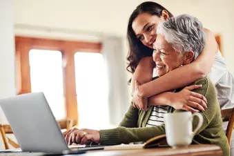 proud young woman hugging her grandmother