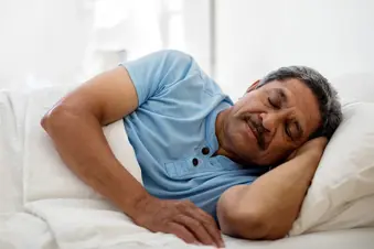 senior man sleeping in bed