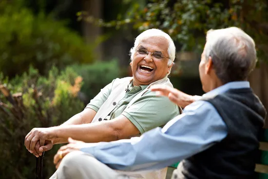 photo of two senior men on bench laughing