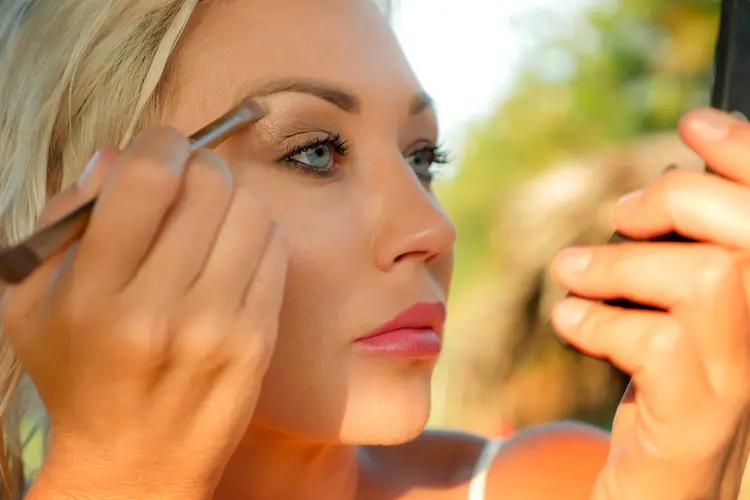 photo of 30s woman applying eye makeup