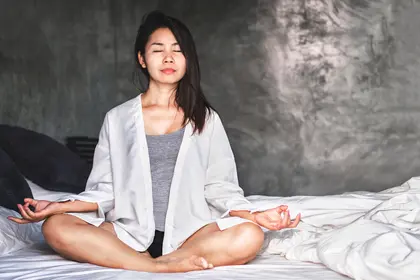 photo of woman on bed meditating