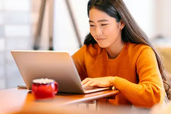 photo of woman using laptop computer at home